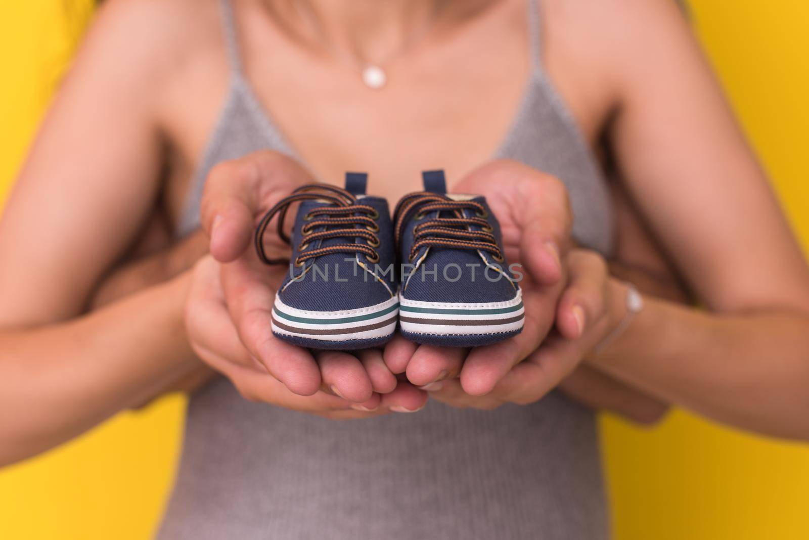 couple holding newborn baby shoes by dotshock