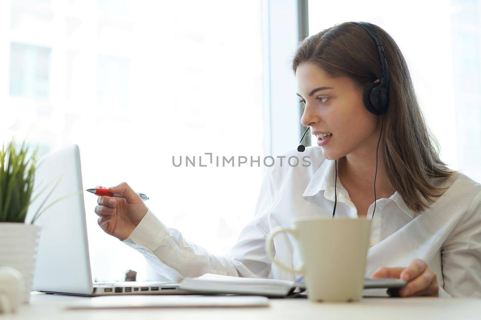 Customer support operator working in a call center office. by tsyhun