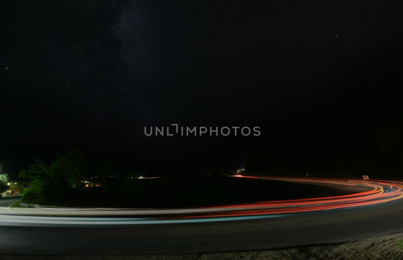 vegicle light trails in night on busy countryroad curve  long exposure