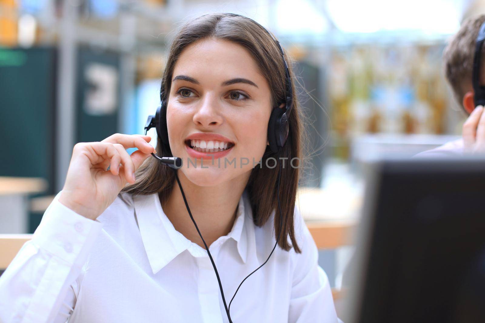 Female customer support operator with headset and smiling.