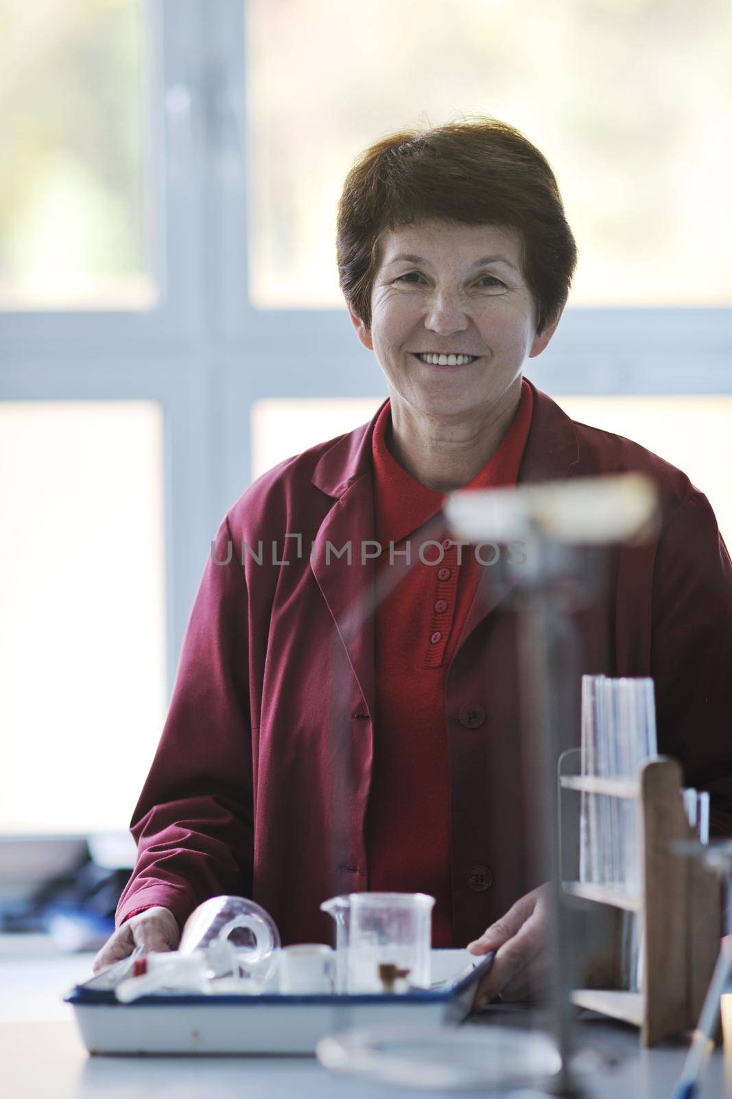 older or senior science and chemistry teacher woman portrait at classroom school indoor
