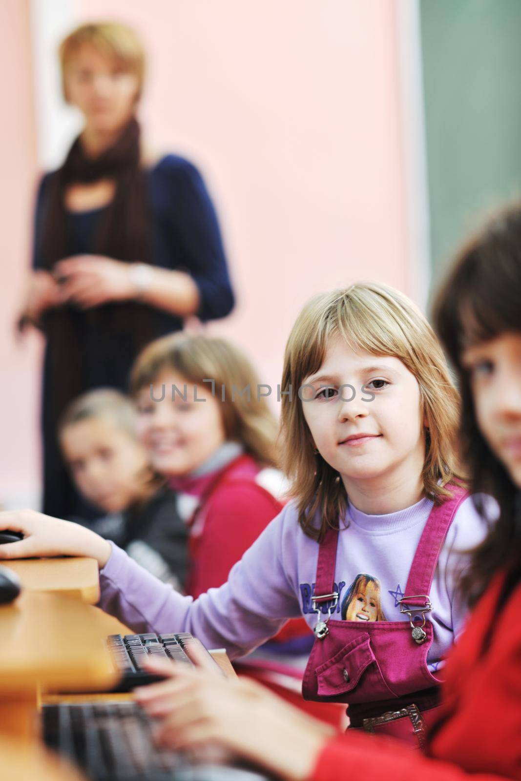 it education with children group  in school at computer science class learning leassons and practice typing 