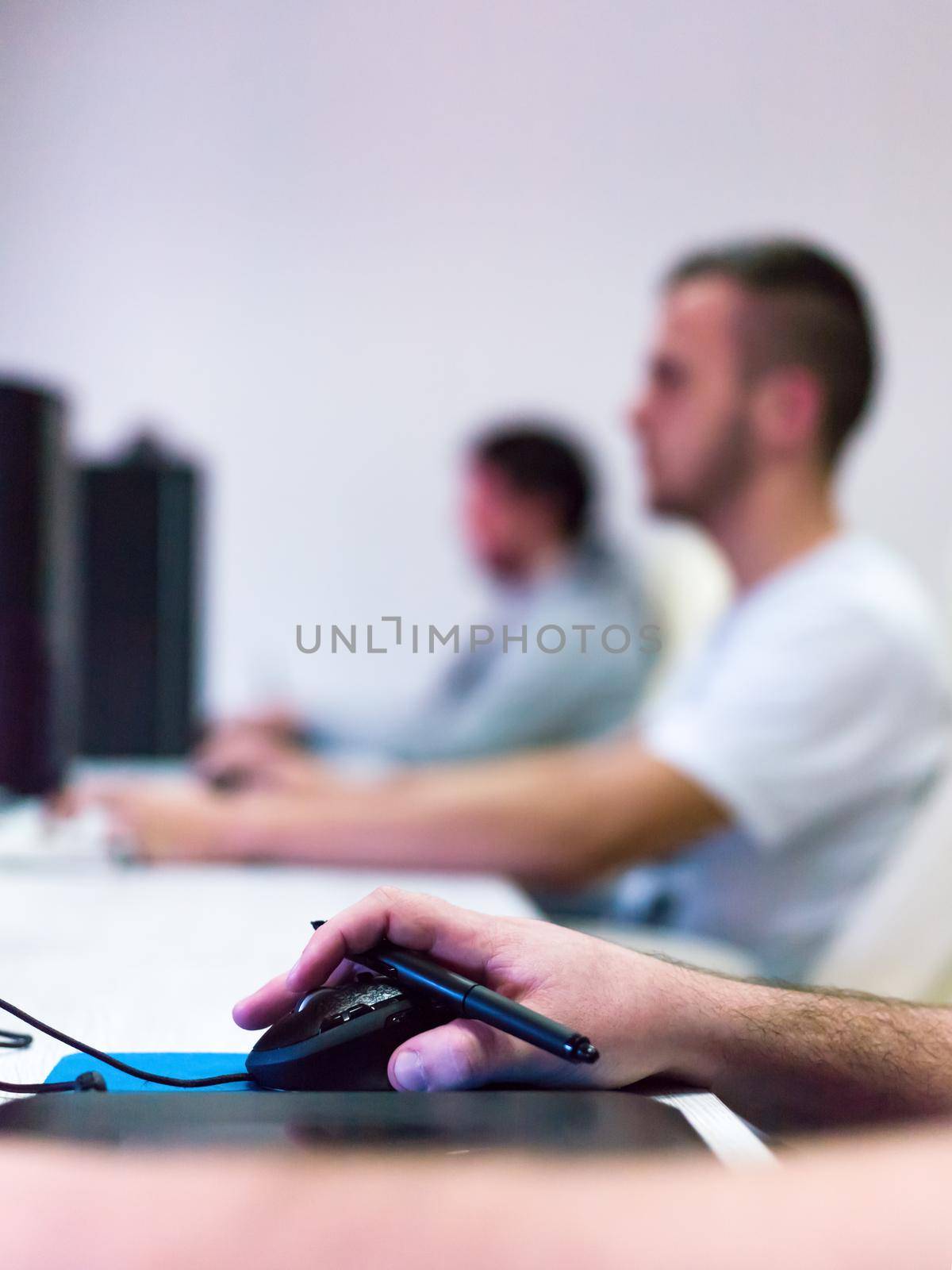 Closeup of Graphic Designer Working at Workplace. Guy Sitting at Table Retouching Photo Using Digital Tablet with Pen and desktop computer Indoors. Freelancing and Distance Job Concept