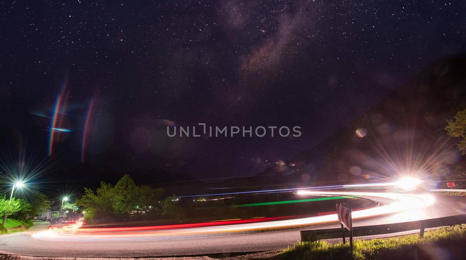 vegicle light trails in night on busy countryroad curve  long exposure