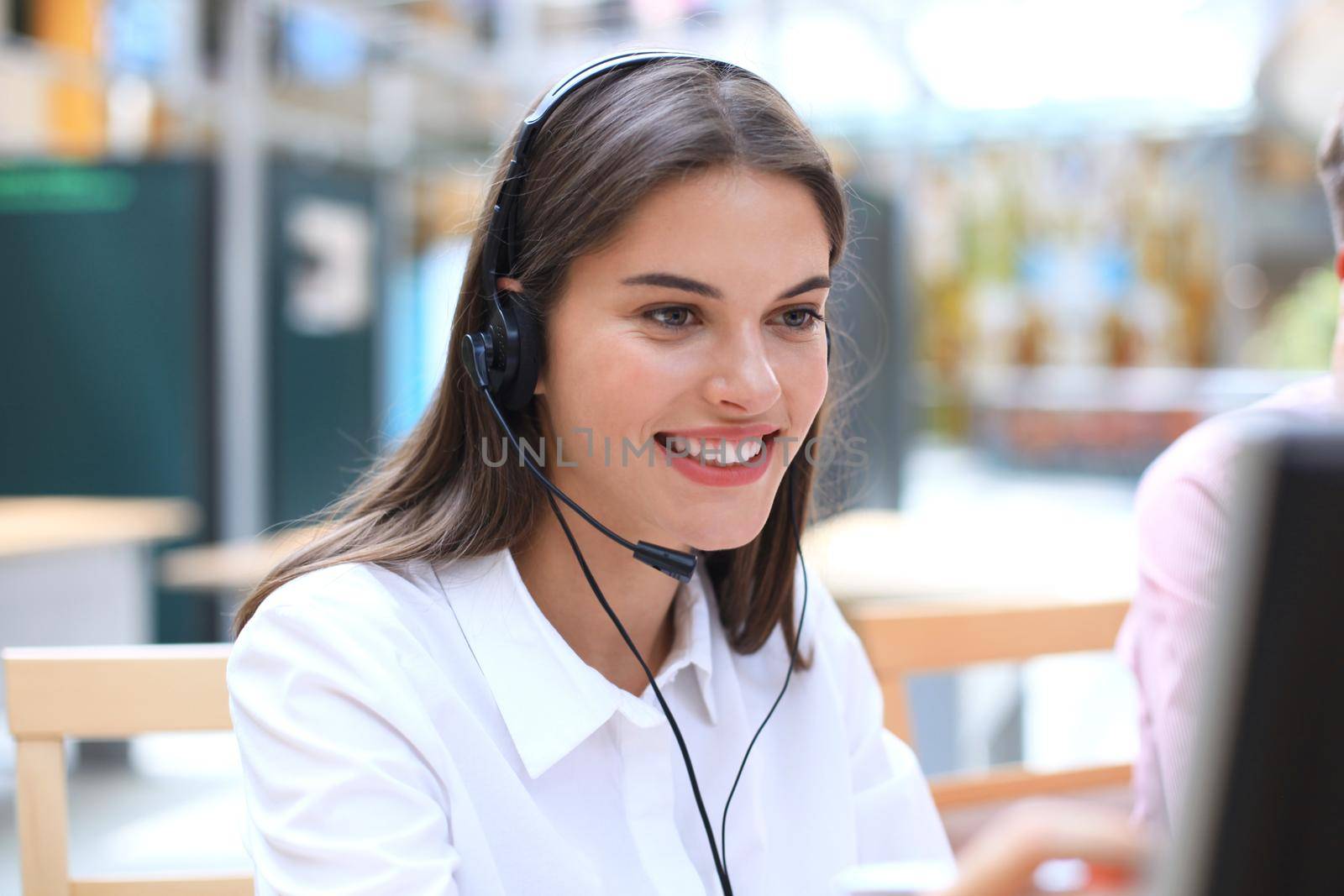 Female customer support operator with headset and smiling.