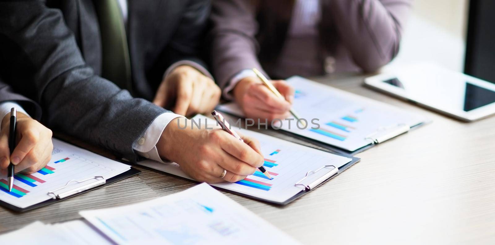 Banking business or financial analyst desktop accounting charts, pens indicates in the graphics by SmartPhotoLab