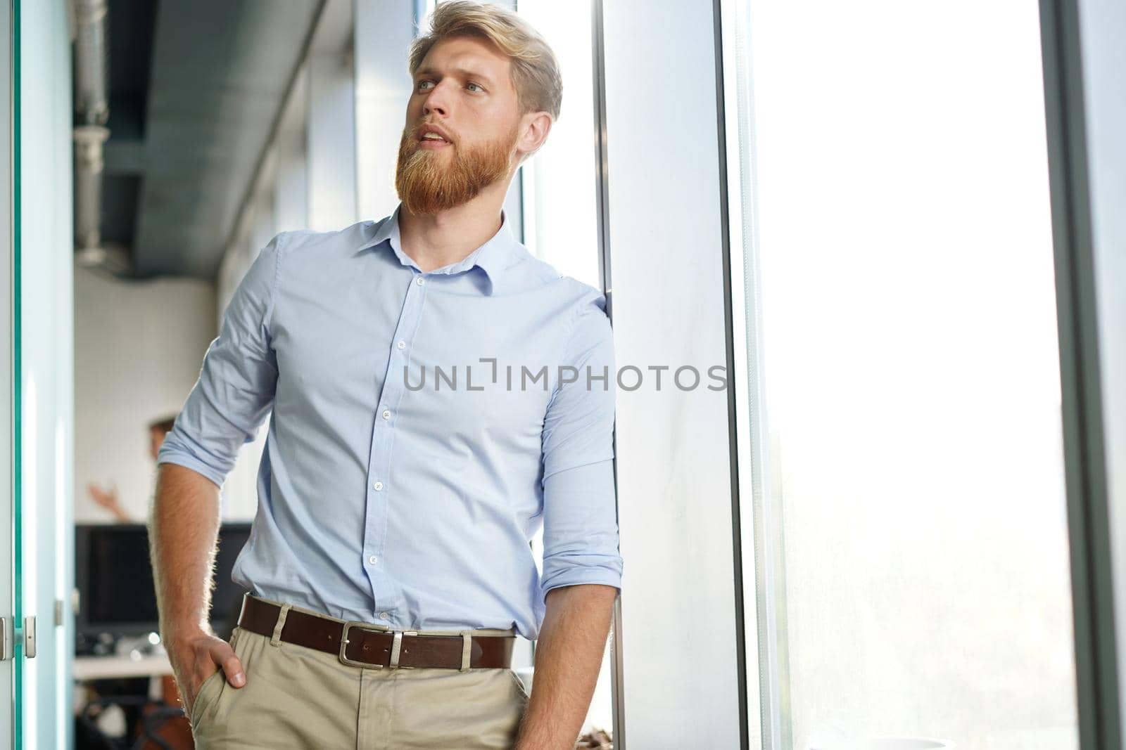 Portrait of a happy young casual businessman at office, smiling.