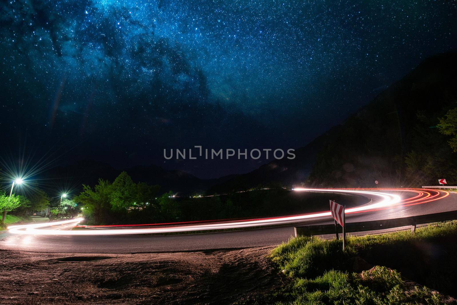 vegicle light trails in night on busy countryroad curve  long exposure