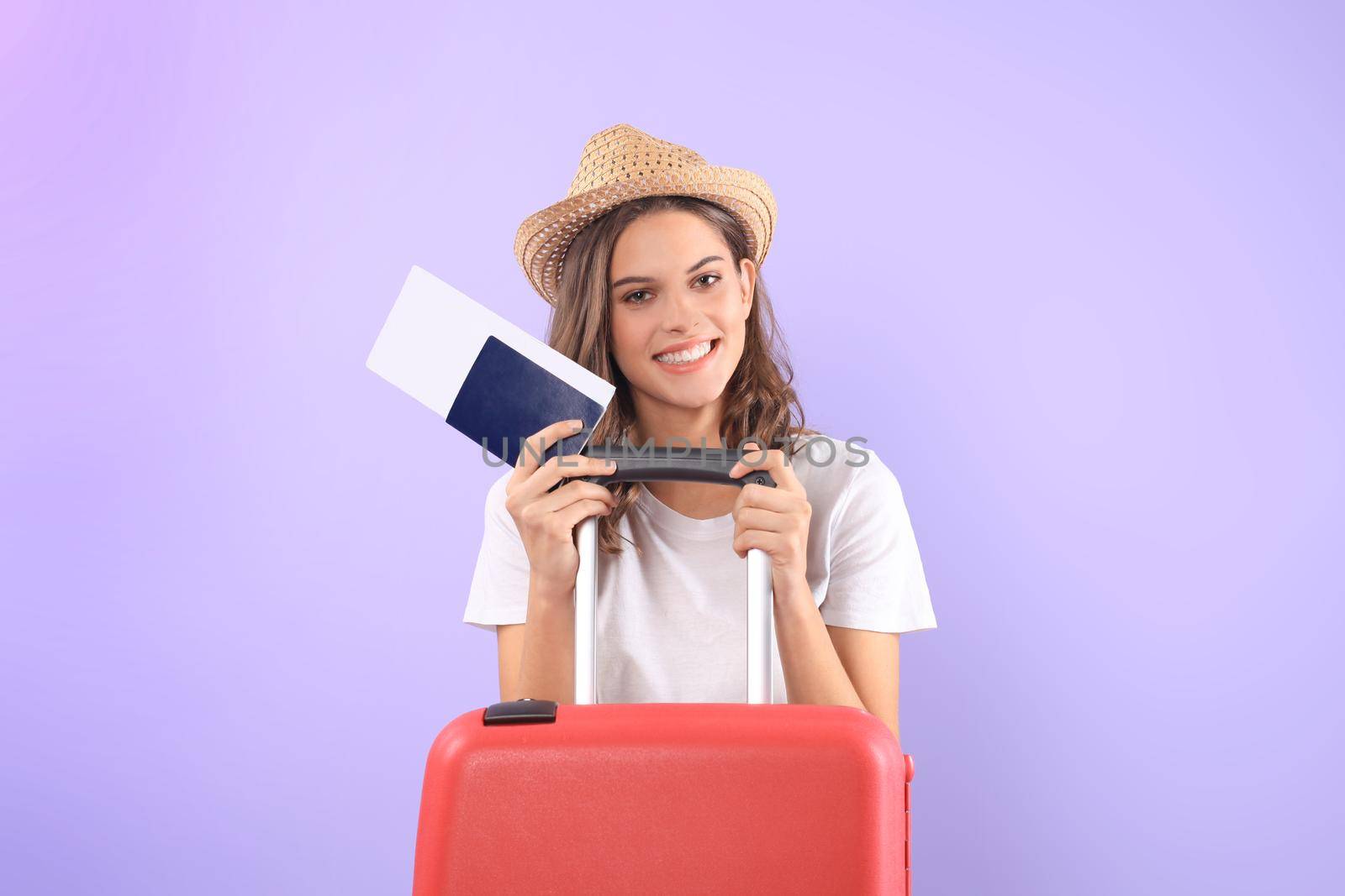 Young tourist girl in summer casual clothes, with sunglasses, red suitcase, passport isolated on purple background