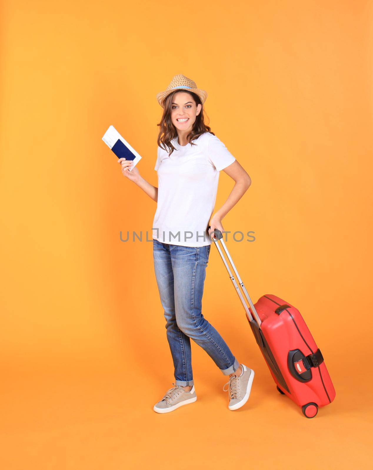 Young tourist girl in summer casual clothes, with red suitcase, passport, tickets isolated on beige background by tsyhun
