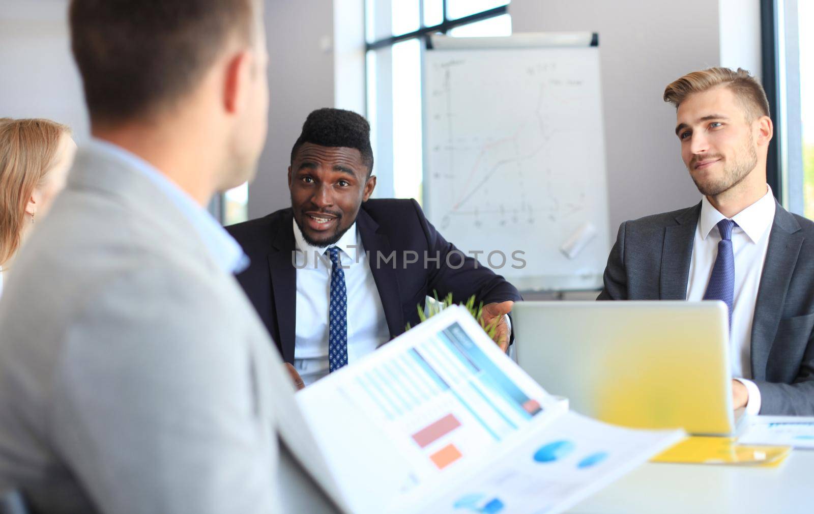 Business people in discussing something while sitting together at the table.