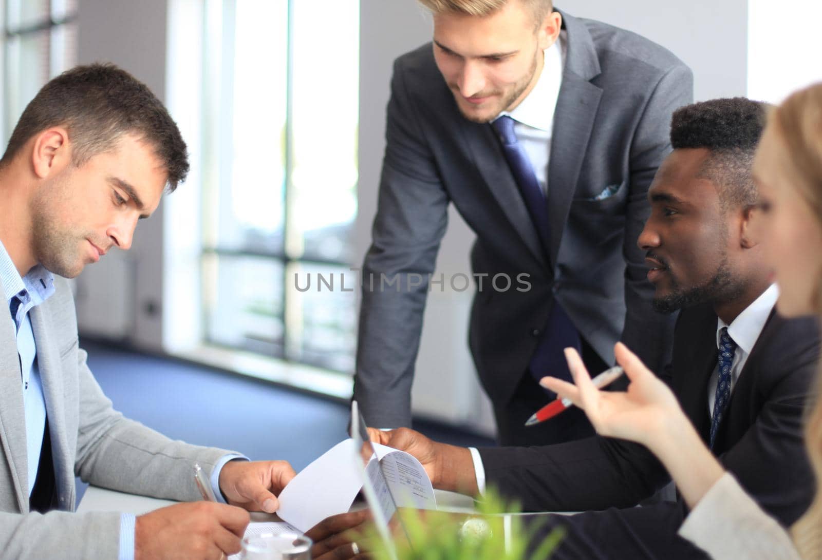Businessman smiling happily as his business partner finally signing important contract.