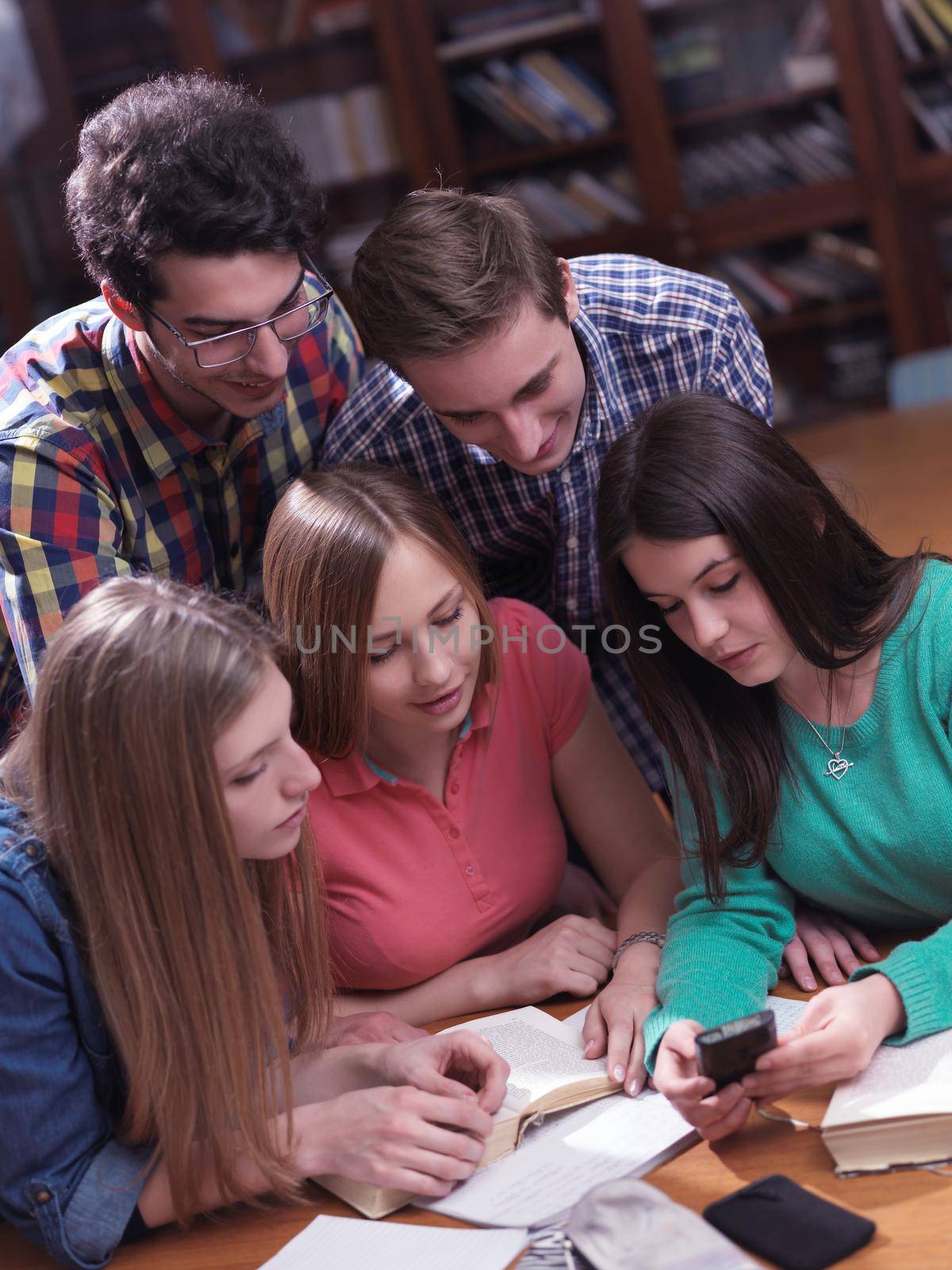 happy young teens group in school on chemisty lessons and library education