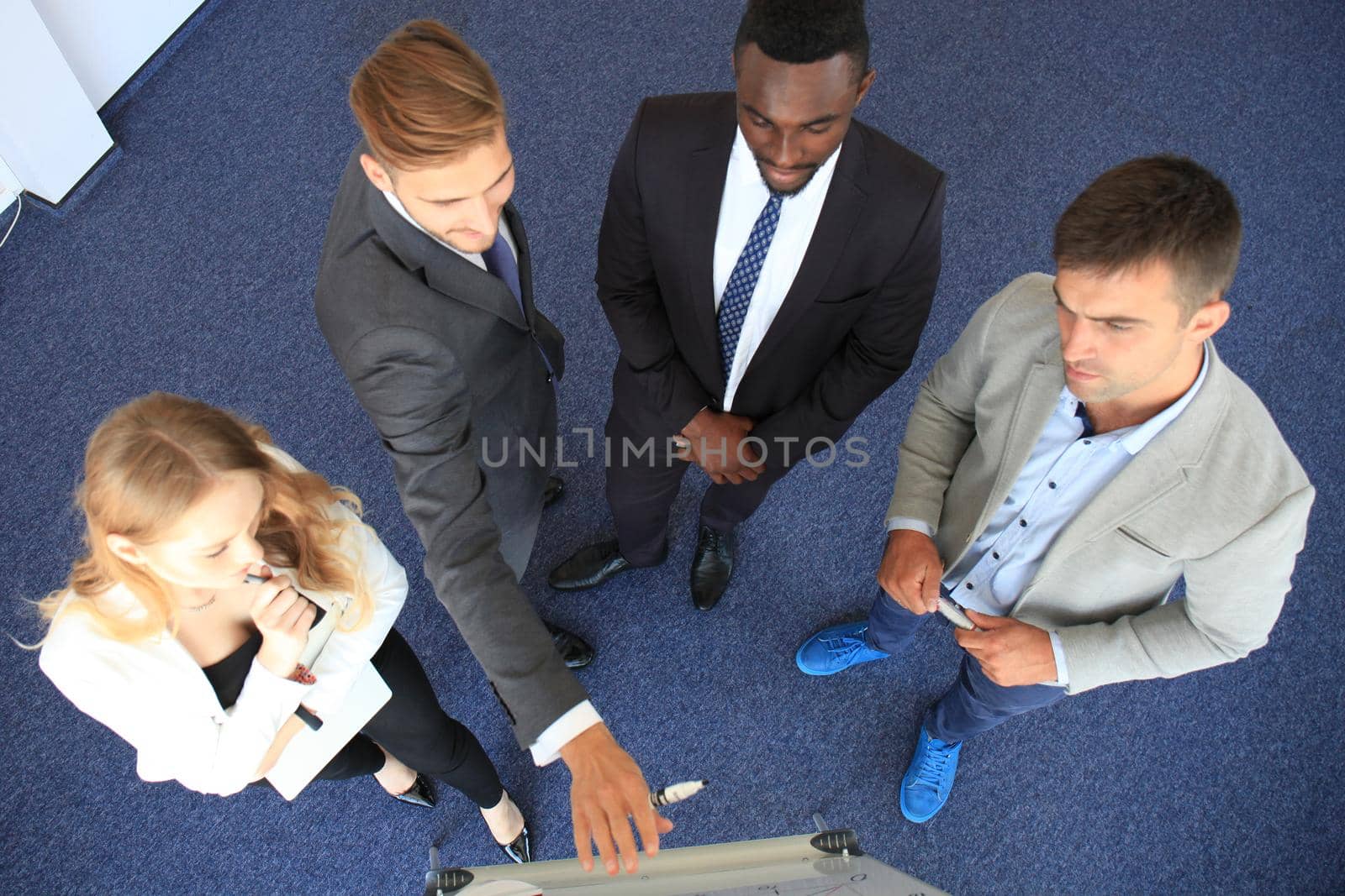 Business people team at presentation working with charts and diargams at flipchart. Top view.