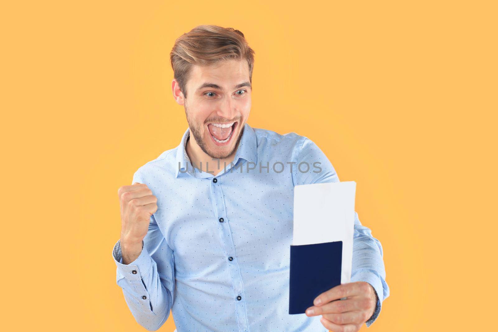 Young man isolated over yellow background holding passport pointing by tsyhun