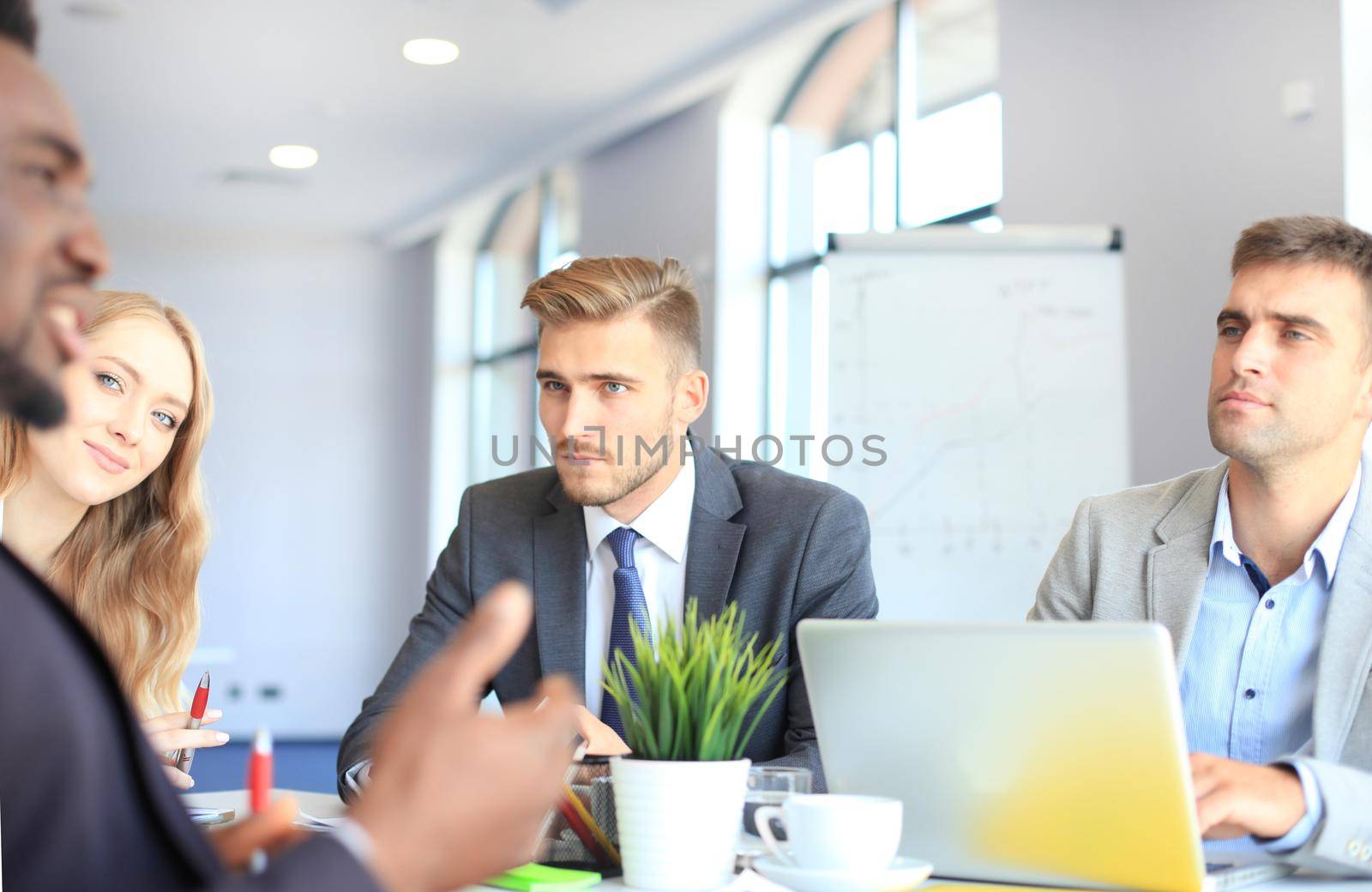 Business people in discussing something while sitting together at the table.