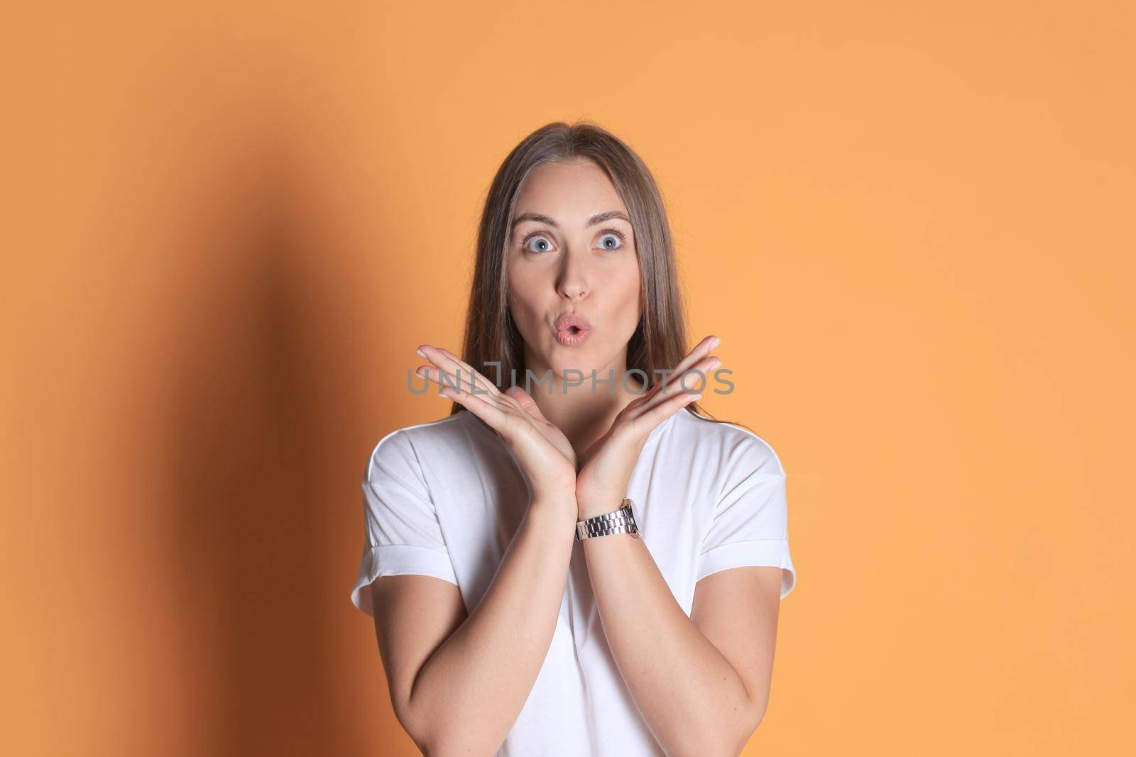 Young woman in casual clothing wondering and screaming isolated over yellow background.