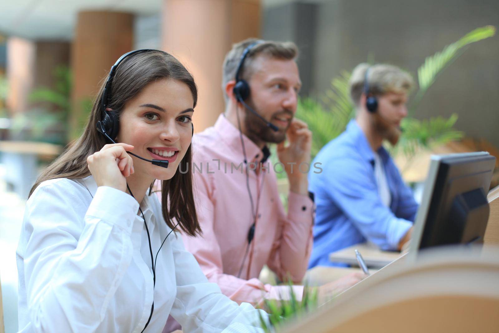 Attractive positive young businesspeople and colleagues in a call center office.