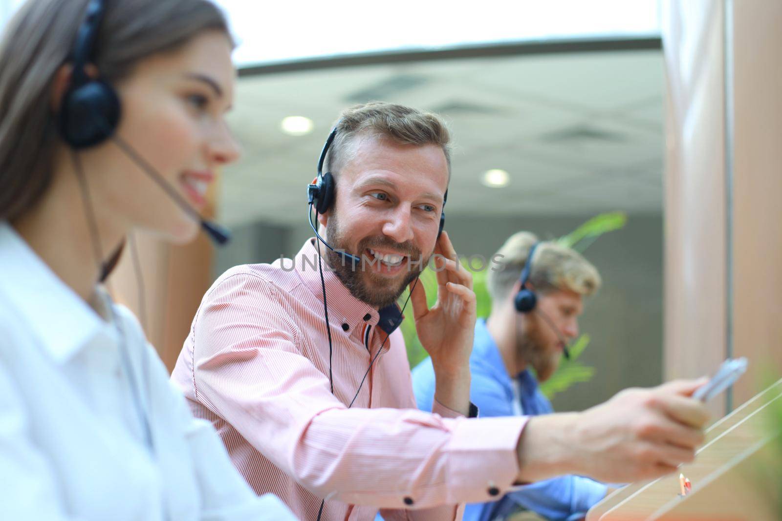 Attractive positive young businesspeople and colleagues in a call center office.