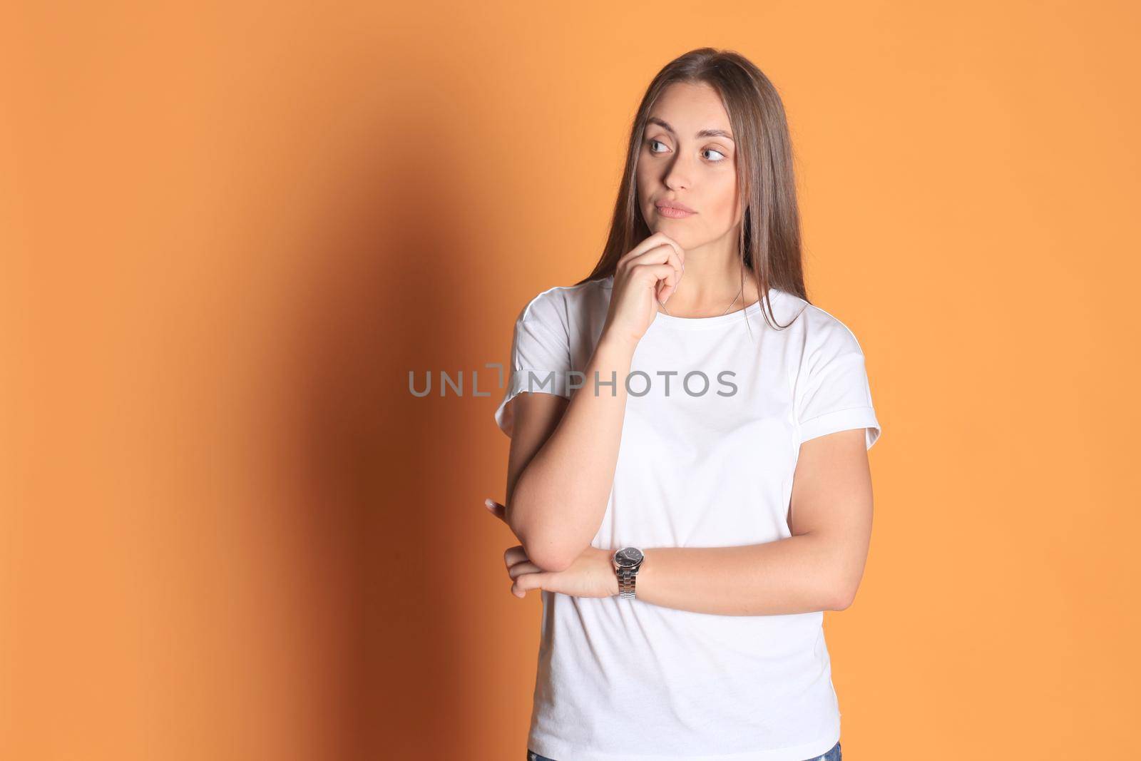 Image of thoughtful young woman posing isolated on yellow background by tsyhun