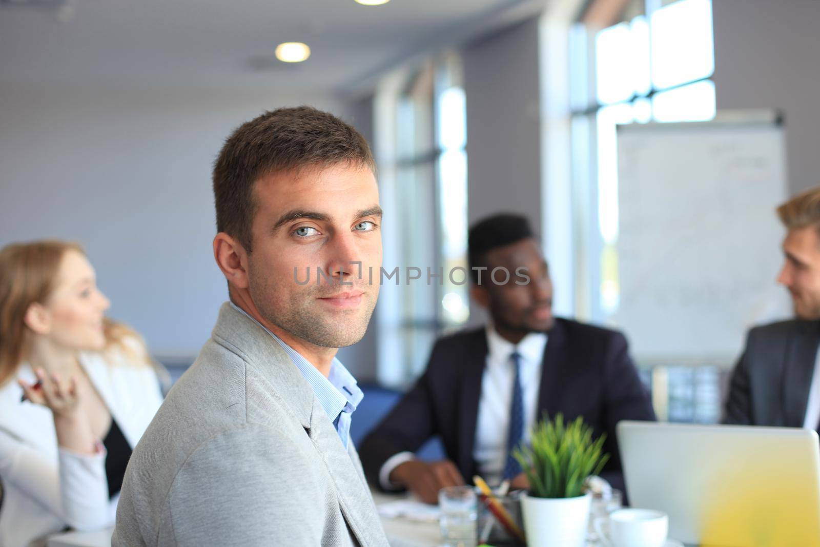 Businessman with colleagues in the background in office.