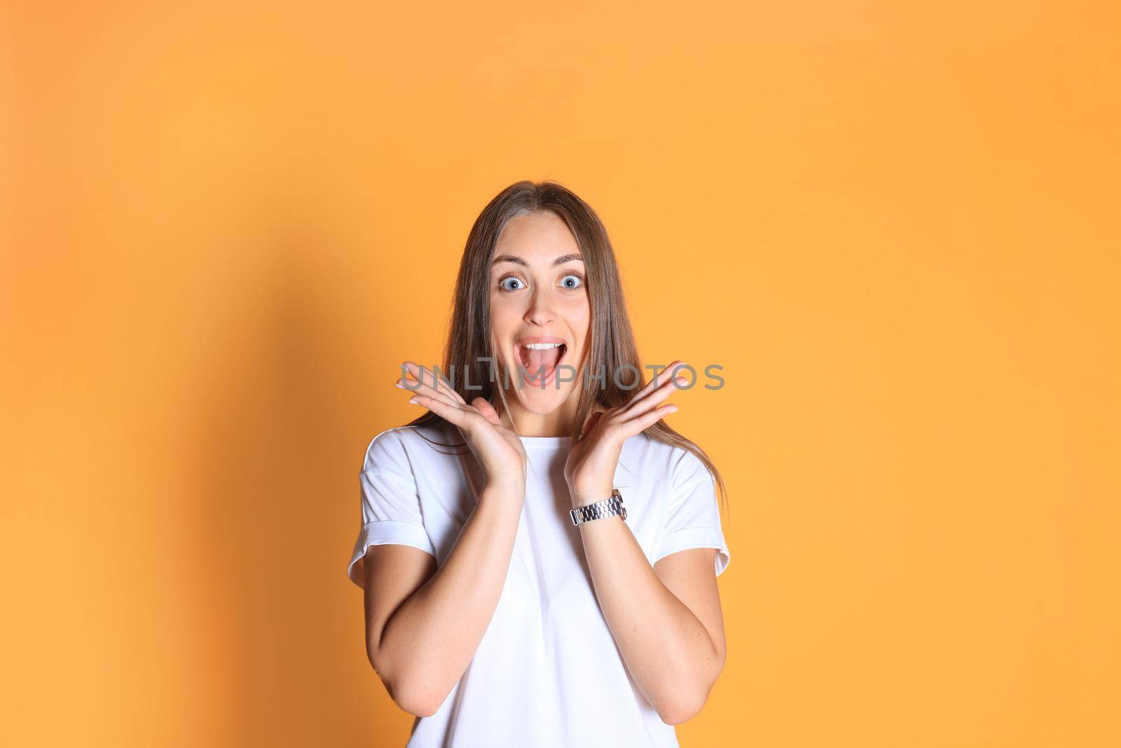 Young woman in casual clothing wondering and screaming isolated over yellow background. by tsyhun