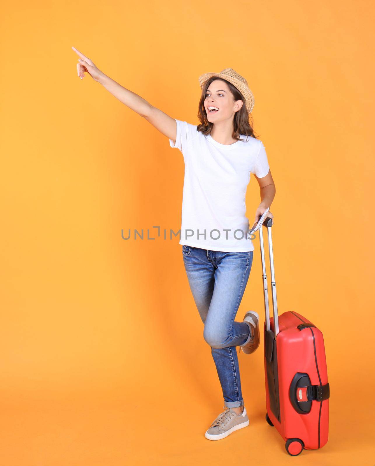 Young tourist girl in summer casual clothes, with red suitcase, passport, tickets isolated on beige background