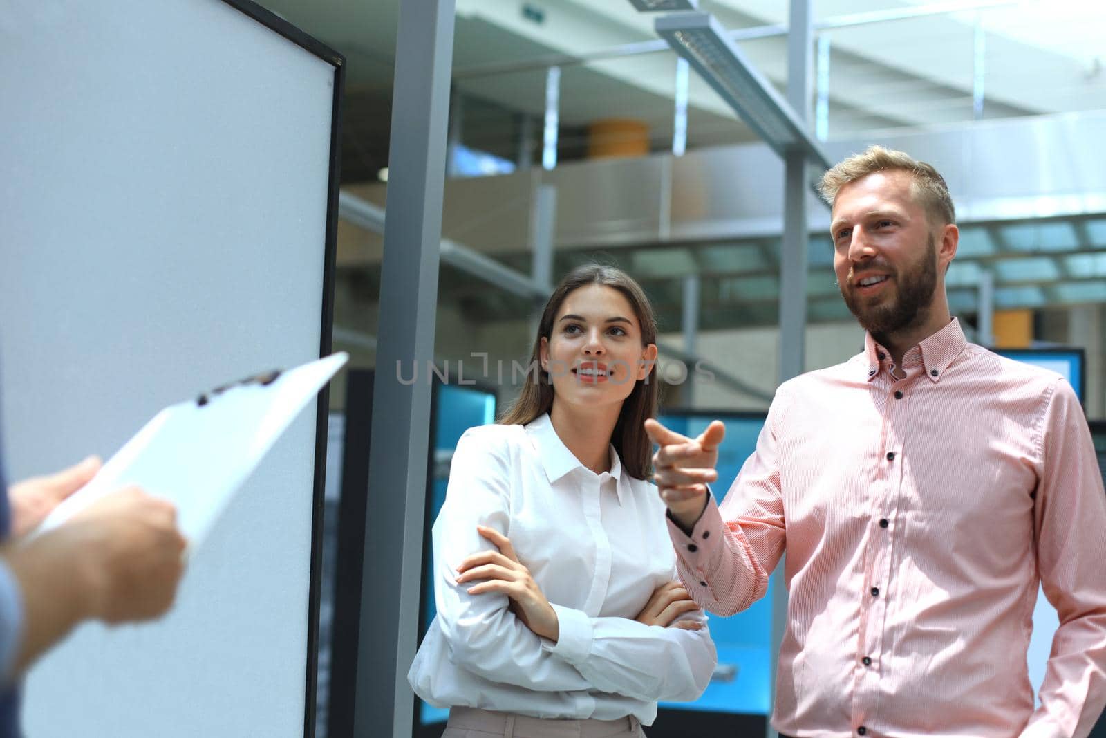 Group of young modern people in smart casual wear having a brainstorm meeting while standing in the creative office