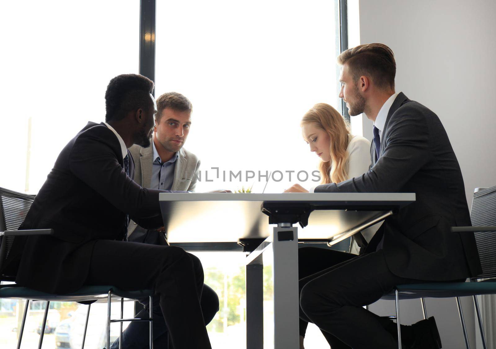 Business people in discussing something while sitting together at the table.