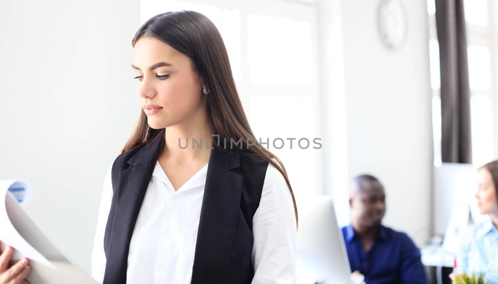 business woman with her staff, people group in background at modern bright office.