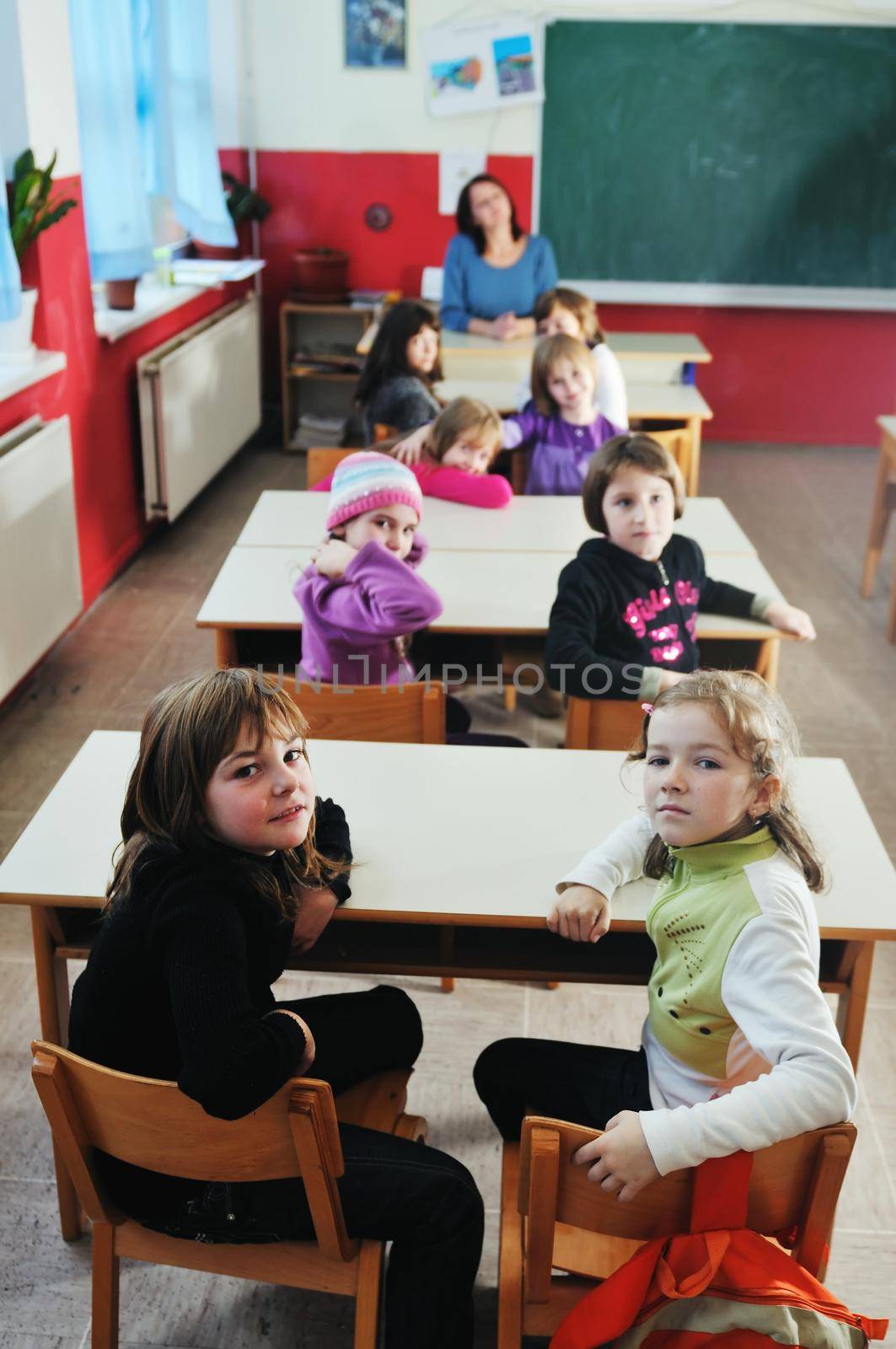 happy young teacher woman at elementrary school teaching and giving leassons to group of young smart children