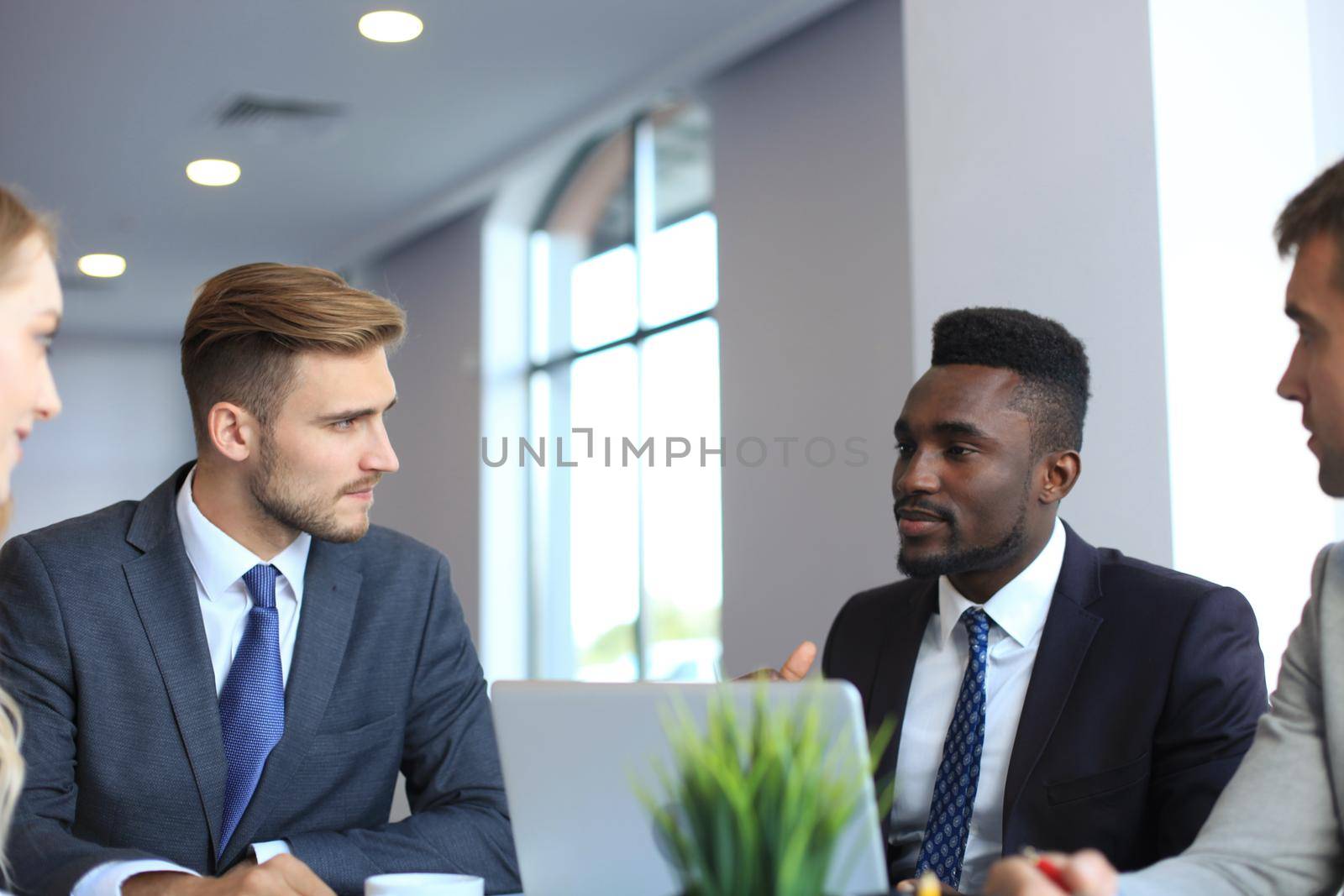 Business people in discussing something while sitting together at the table.