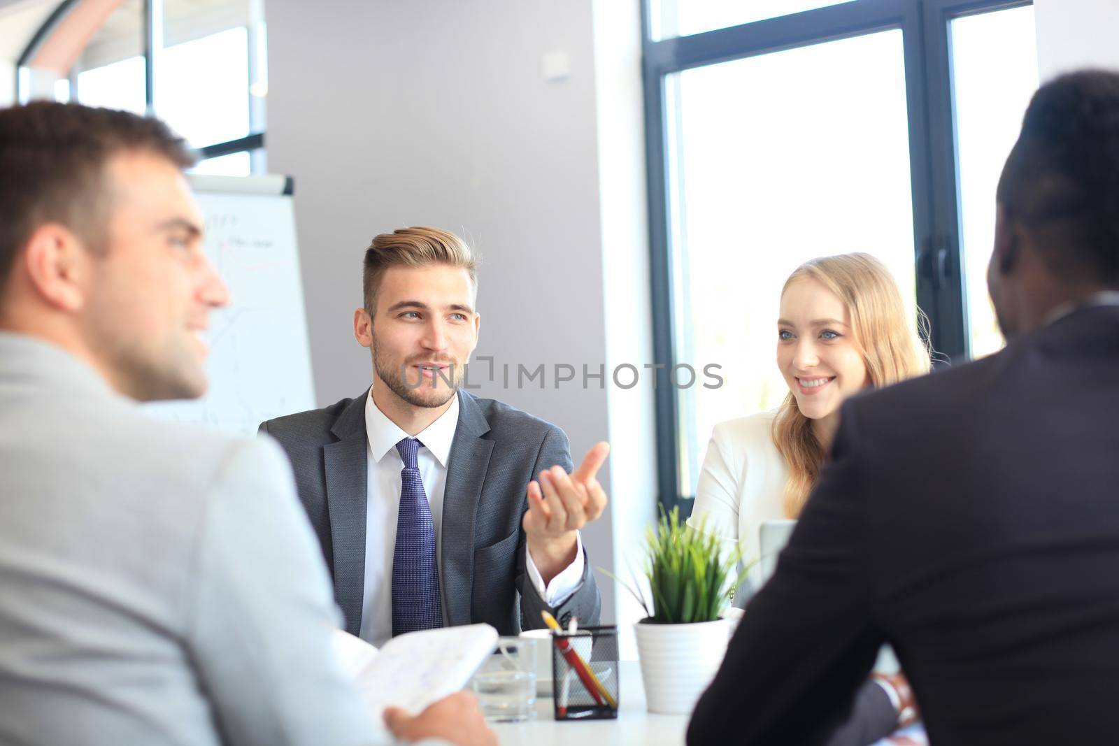 Business people in discussing something while sitting together at the table.