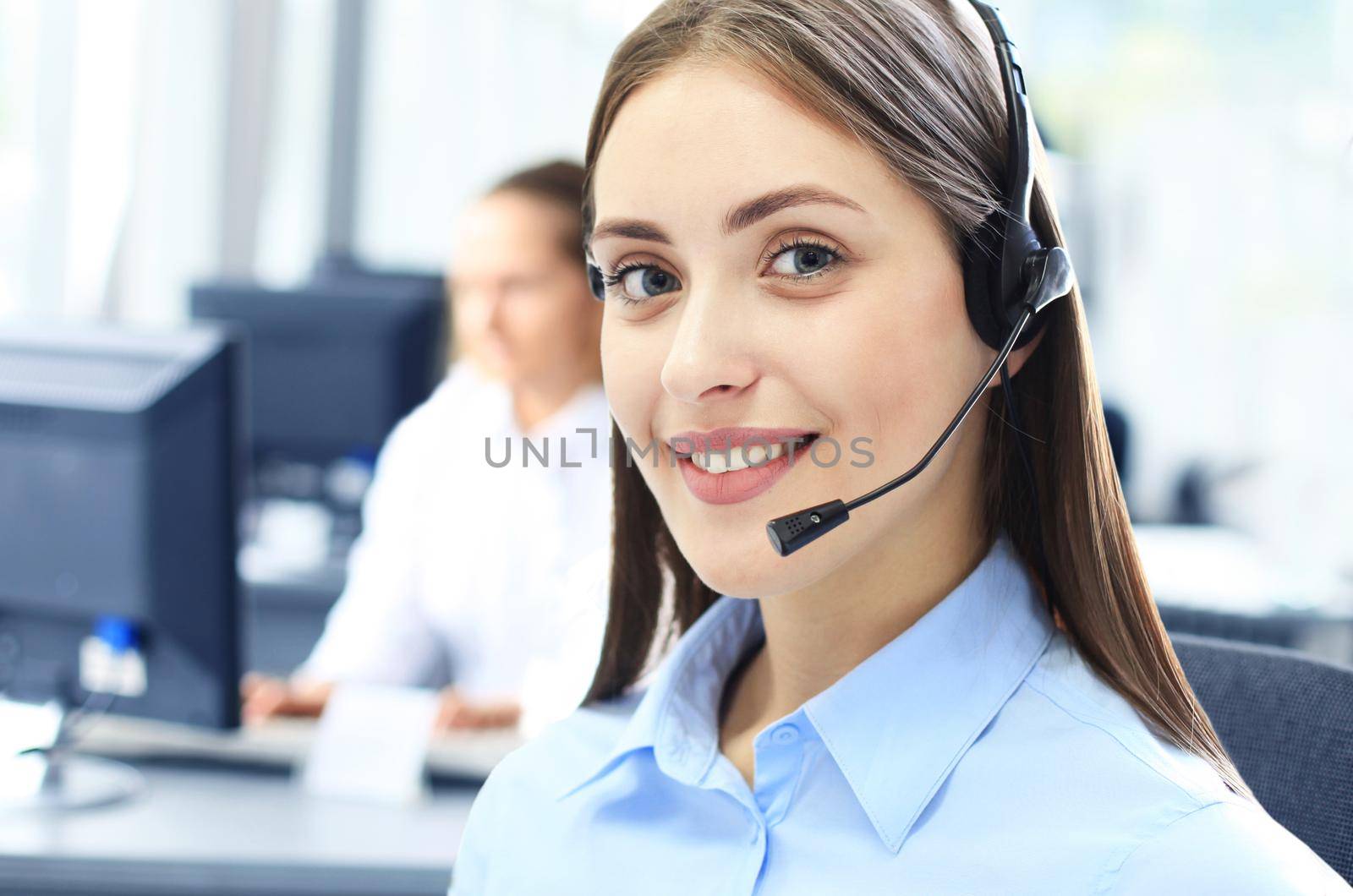 Businesswoman wearing microphone headset using computer in the office - operator, call center. by tsyhun