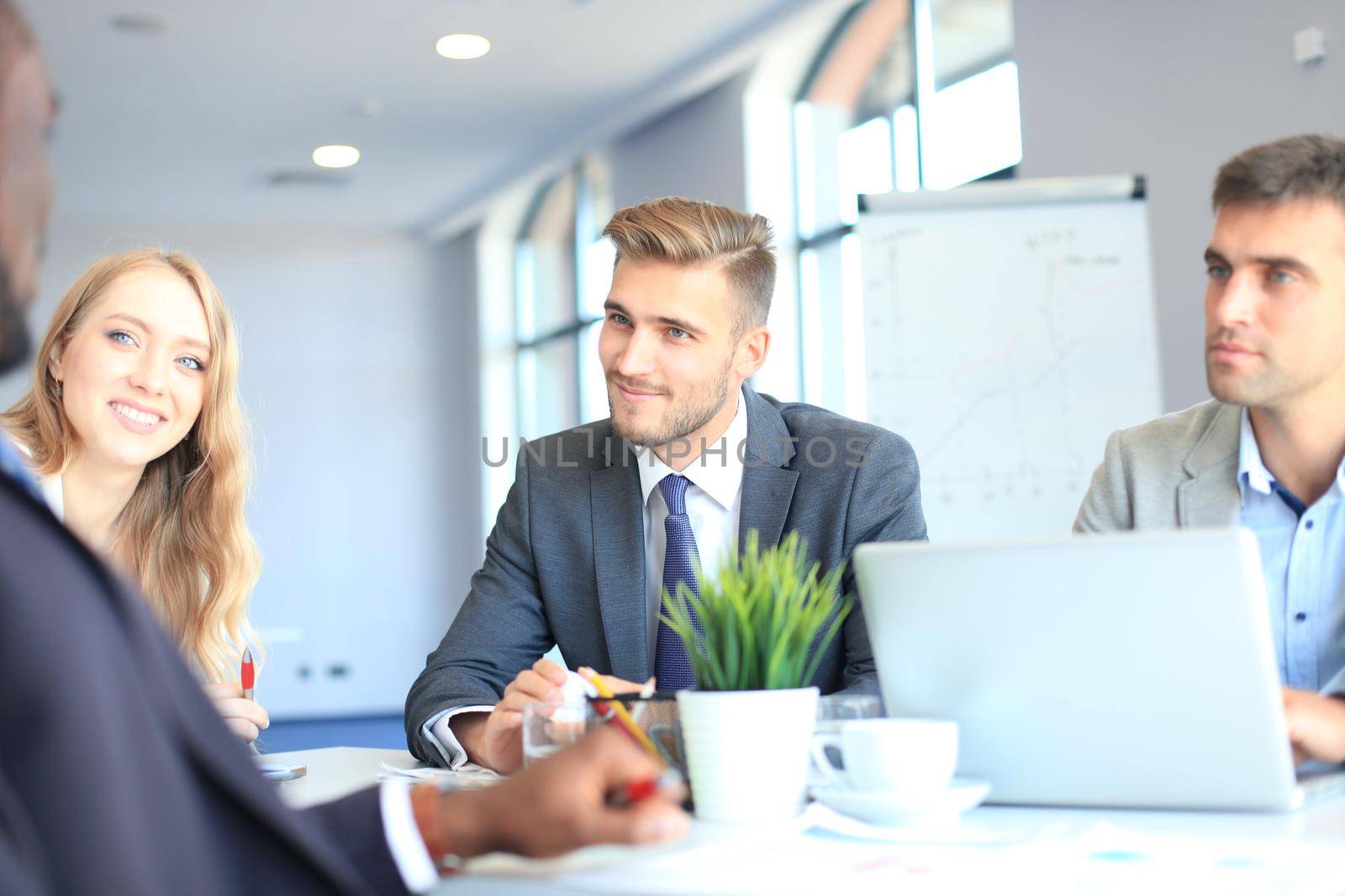 Business people in discussing something while sitting together at the table.