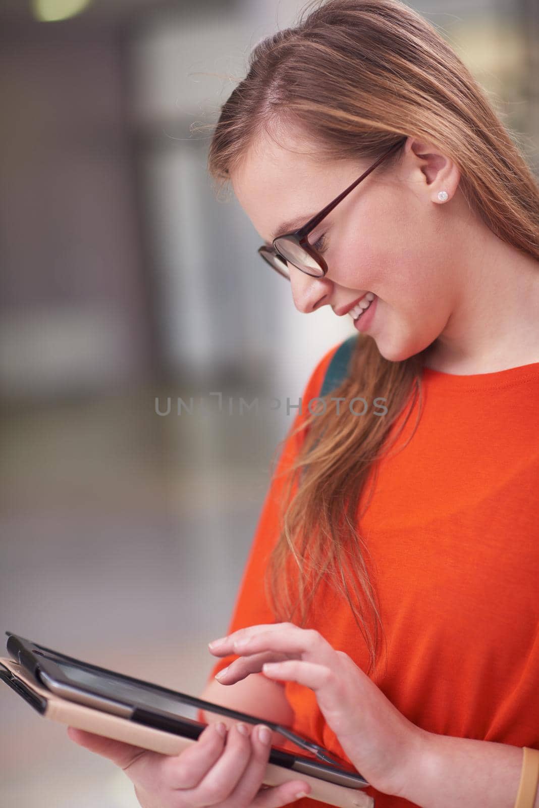 happy student girl working on tablet computer at modern school university indoors