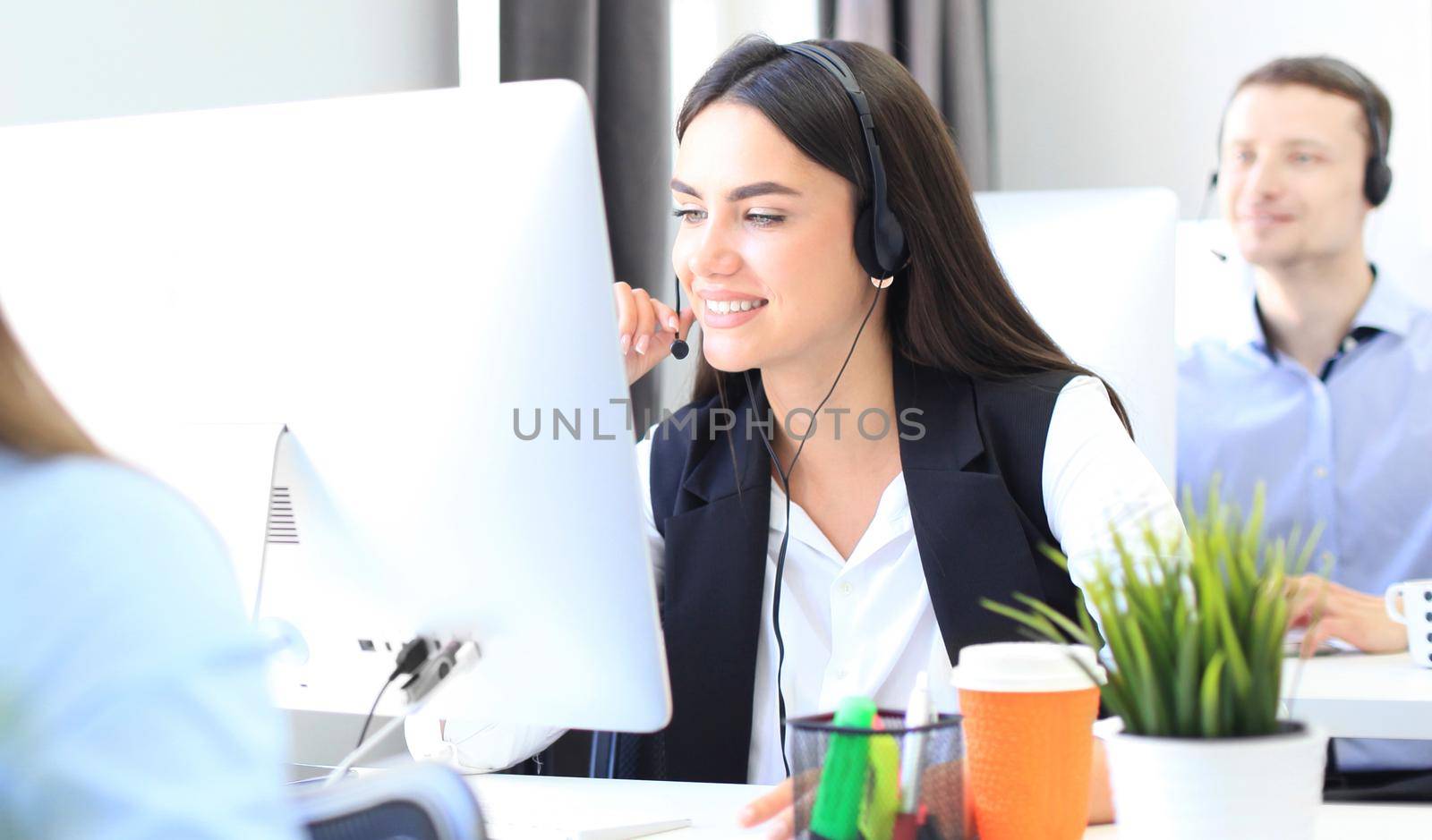 Attractive positive young businesspeople and colleagues in a call center office