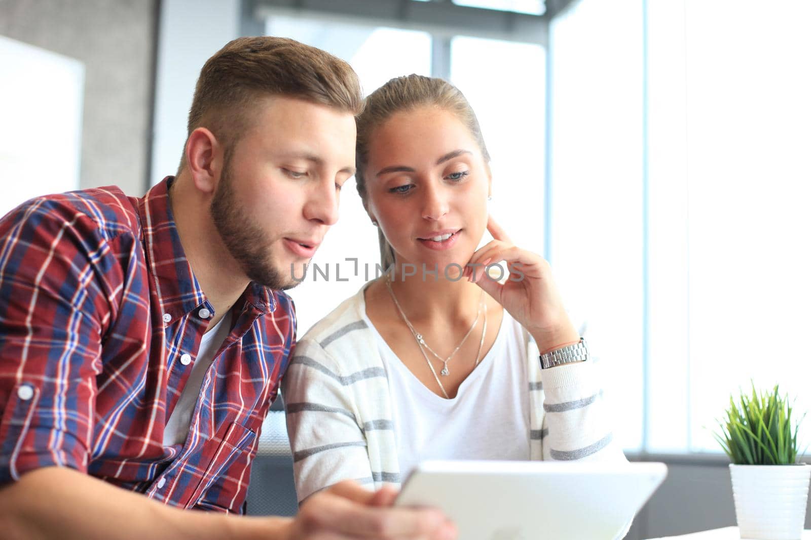 Image of two young business partners discussing plans or ideas at meeting by tsyhun