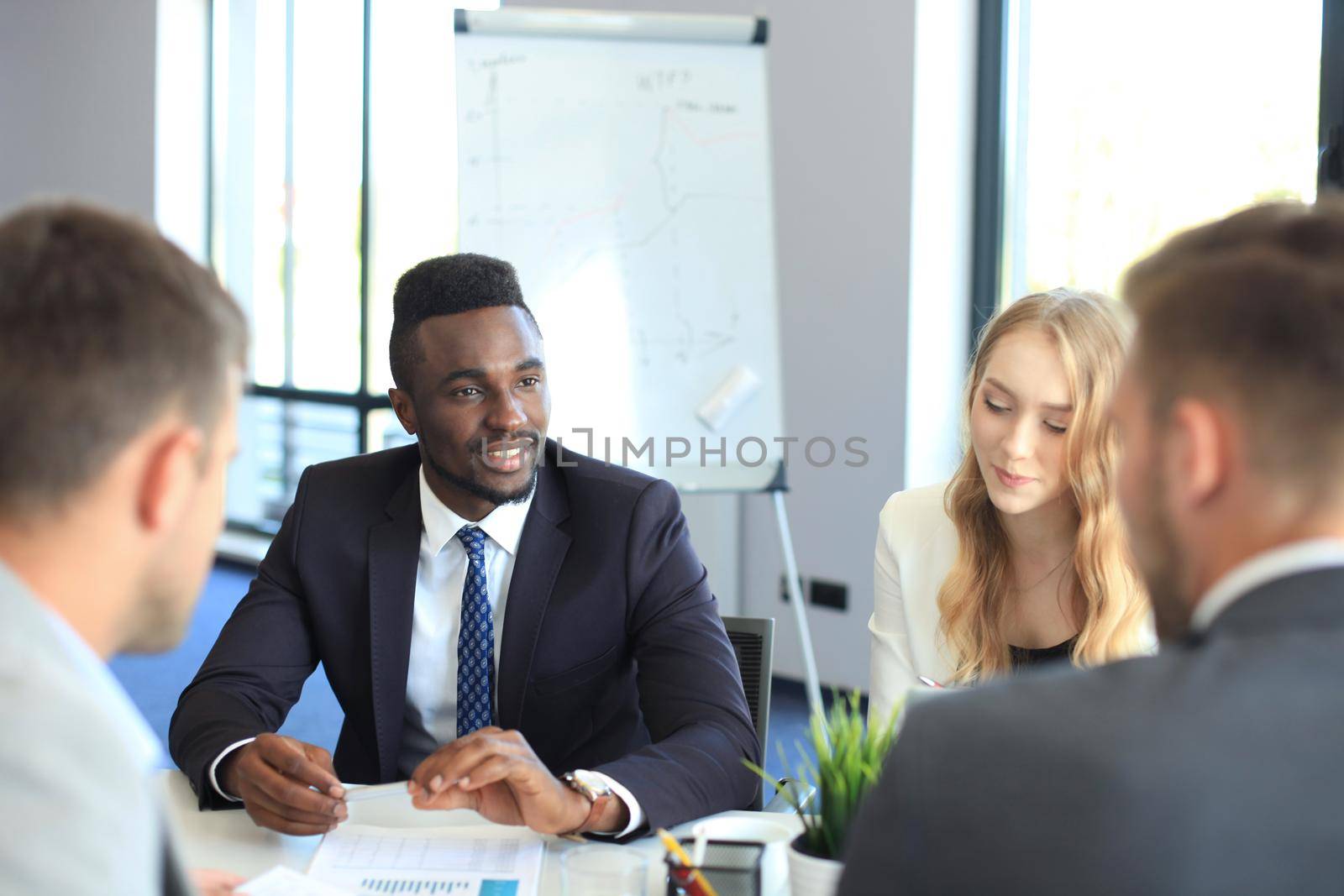 Business people in discussing something while sitting together at the table.