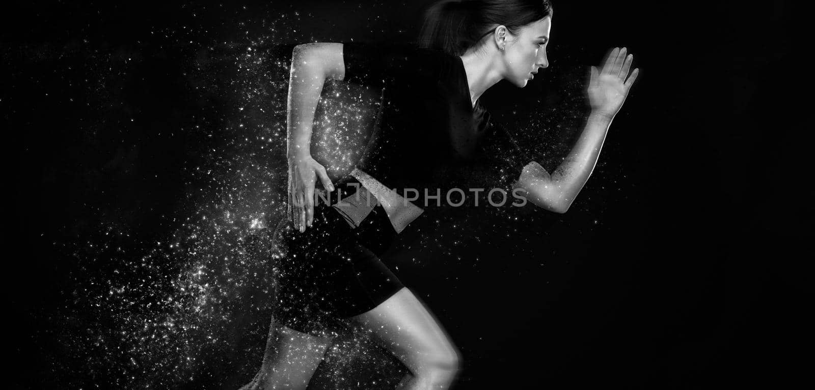 Fitness and sport motivation.. Strong and fit athletic, woman sprinter or runner, running on black background in the fire wearing sportswear. by MikeOrlov