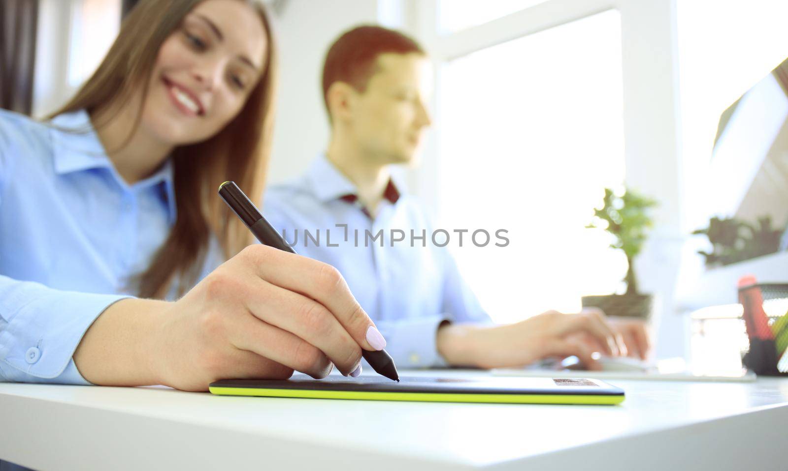 Graphic designer using digital tablet and computer in the office