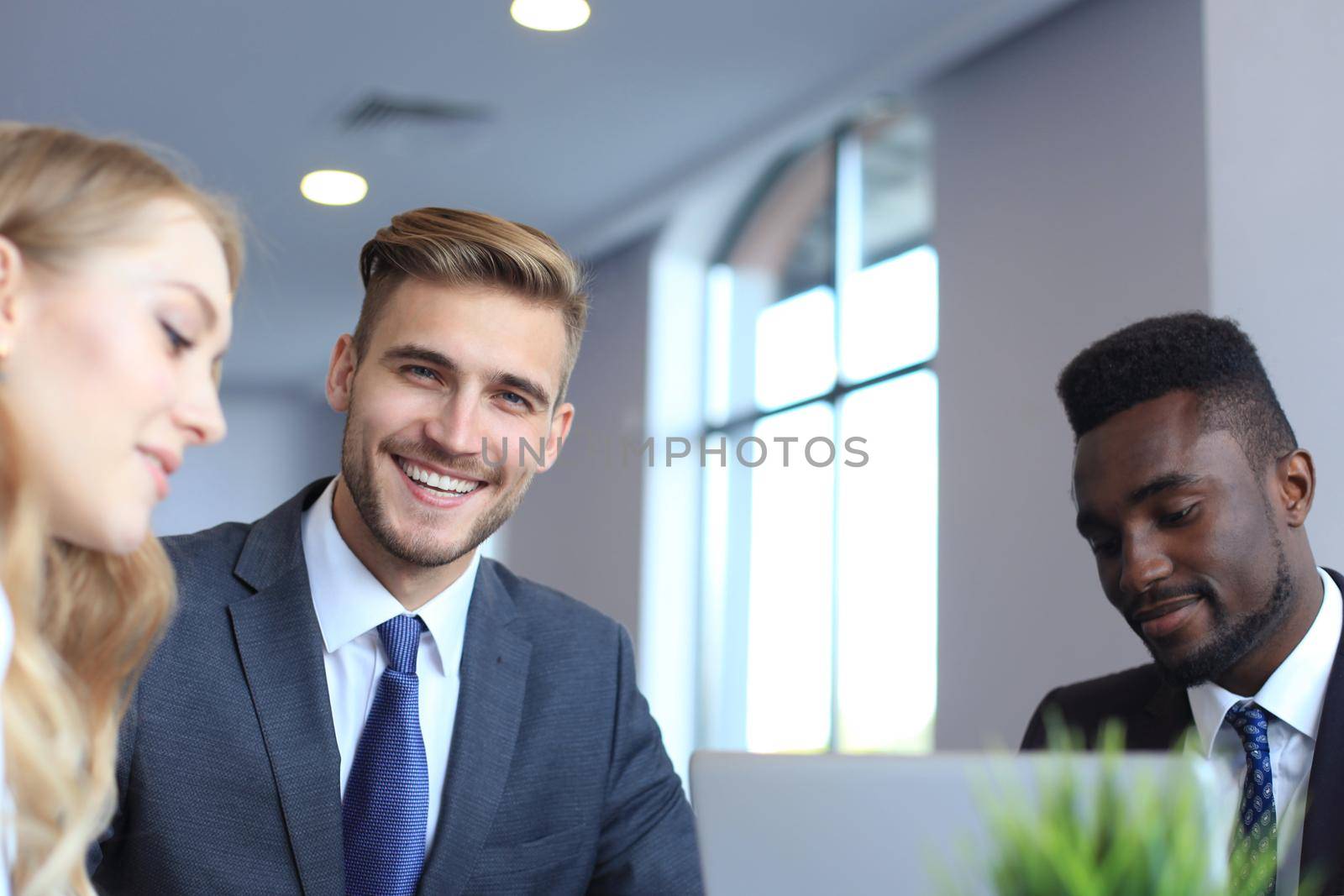 Businessman with colleagues in the background in office.