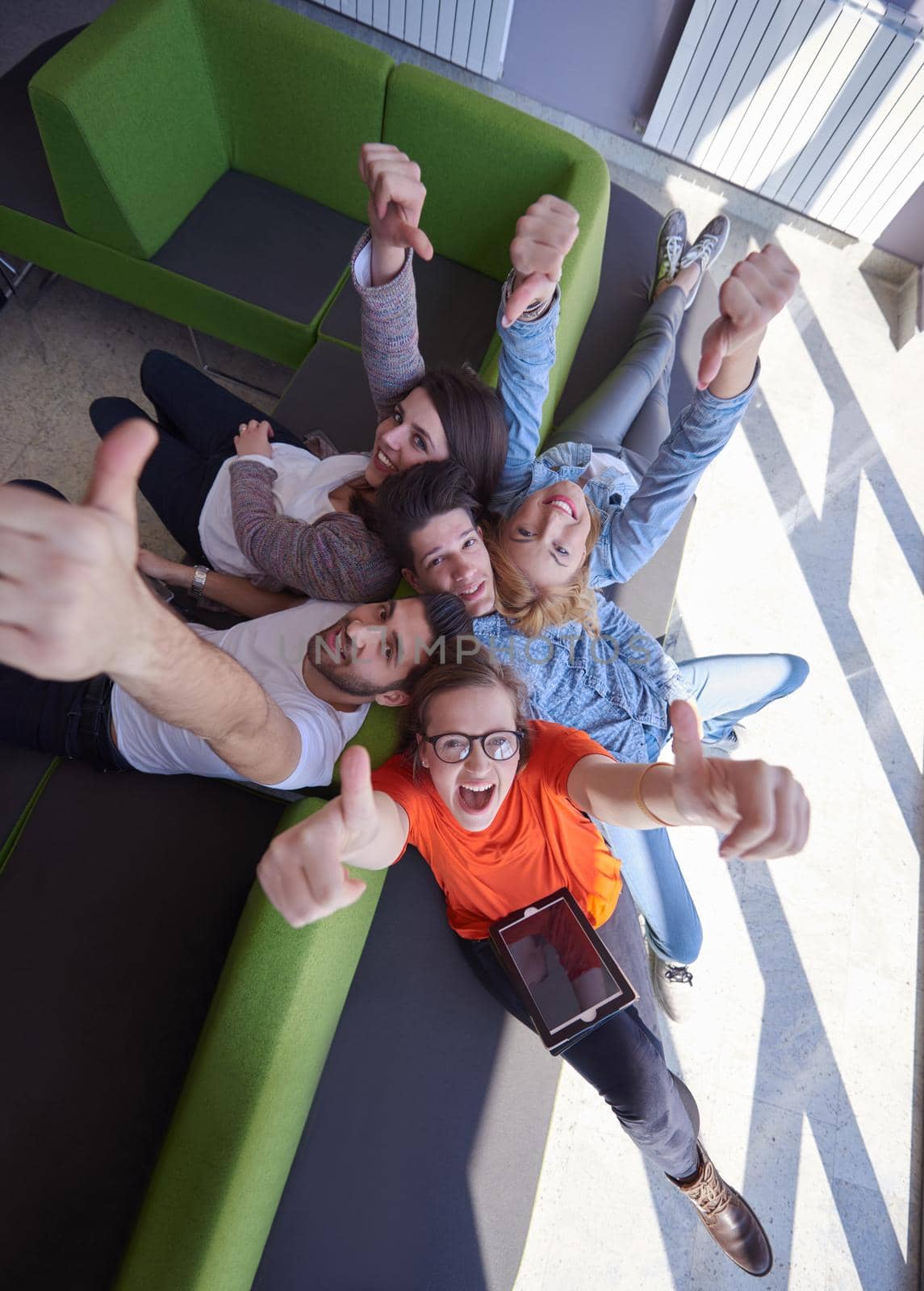 students group working on school  project  together on tablet computer  at modern university