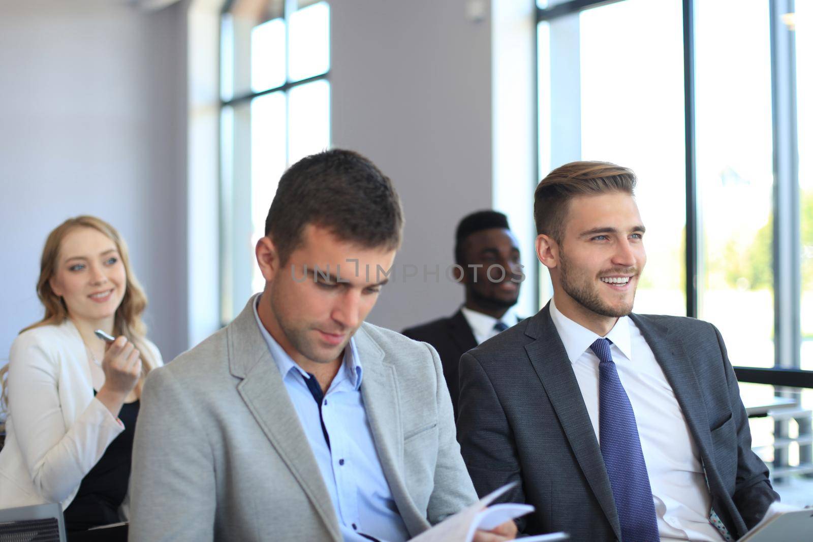 Group of businessmen sitting in conference to speech while having business meeting. by tsyhun