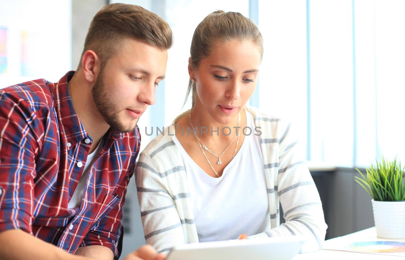 Image of two young business partners discussing plans or ideas at meeting by tsyhun