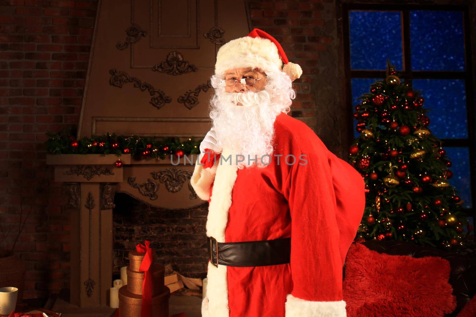 Santa Claus holding carrying sack with gifts for kids.