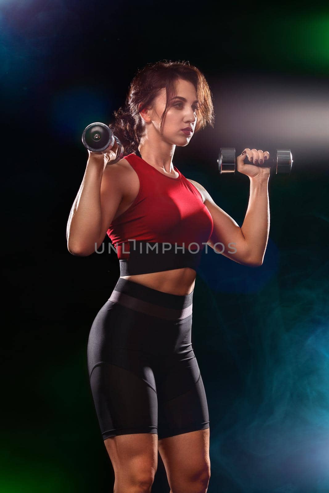 Sporty and fit woman doing exercising at black background to stay fit.