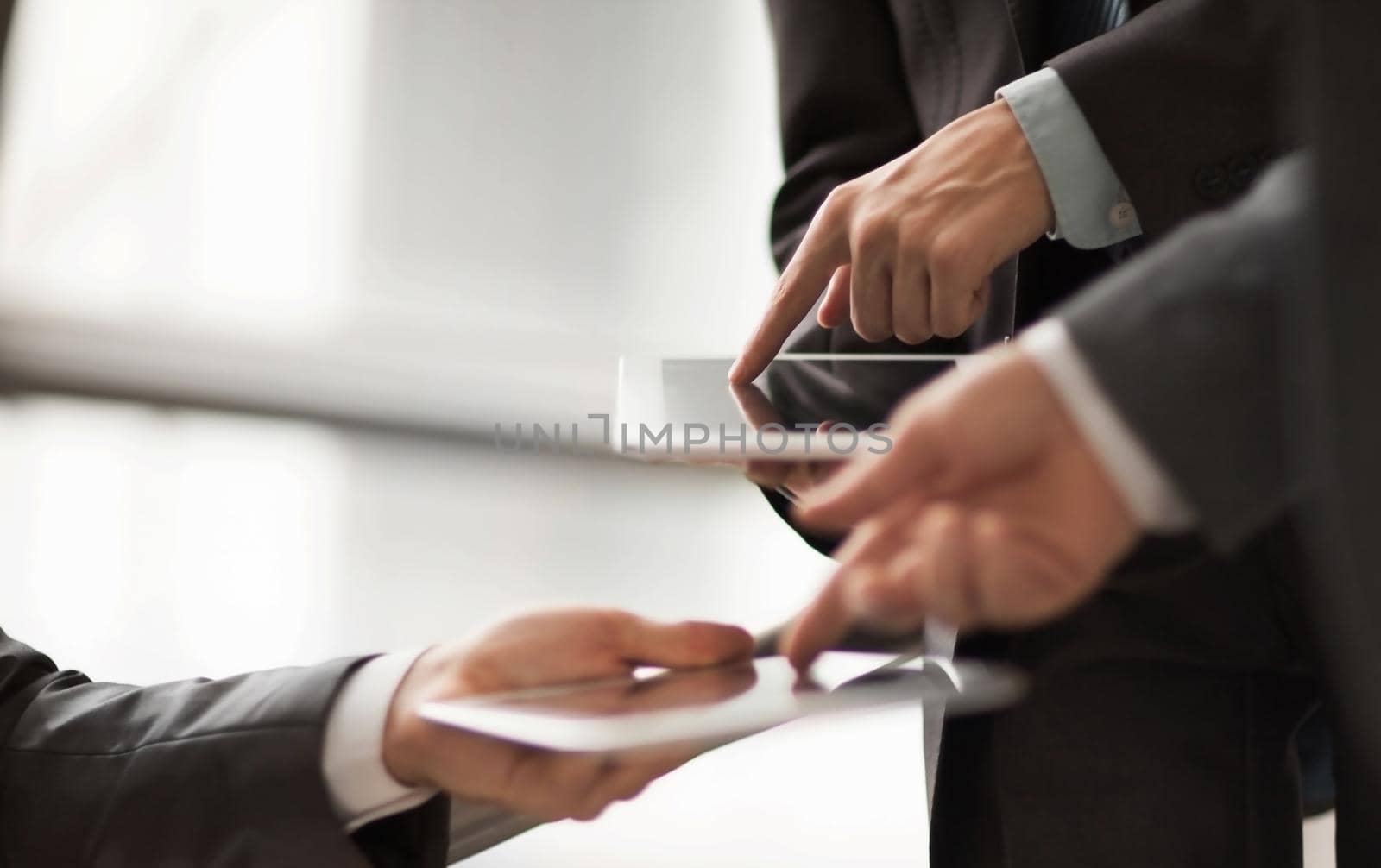 Hands of people working with tablet computer in office