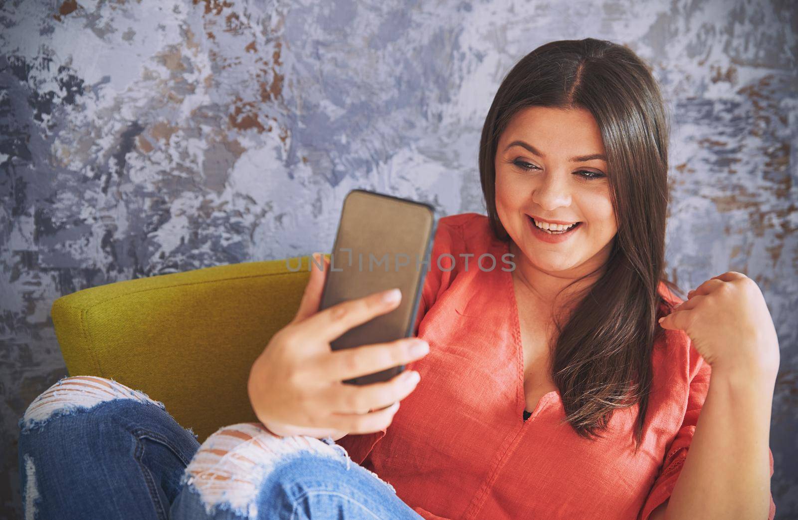 Plus size model sitting on the chair and making selfie by Novic