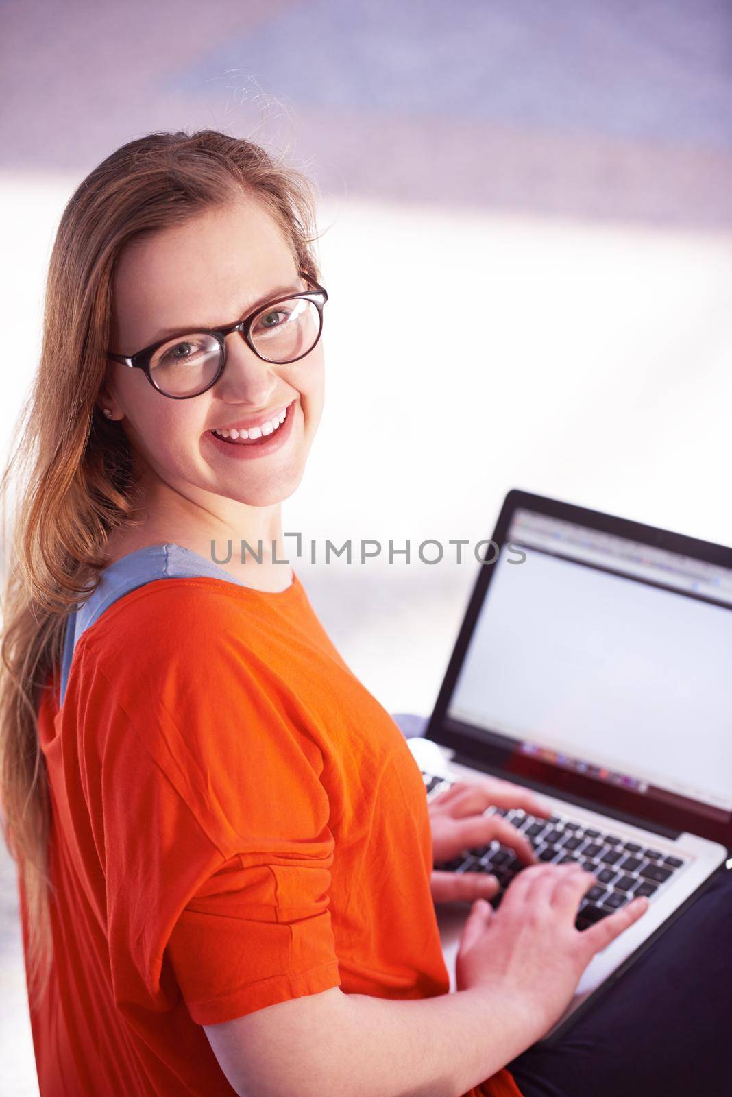 happy student girl working on laptop computer at modern school university indoors